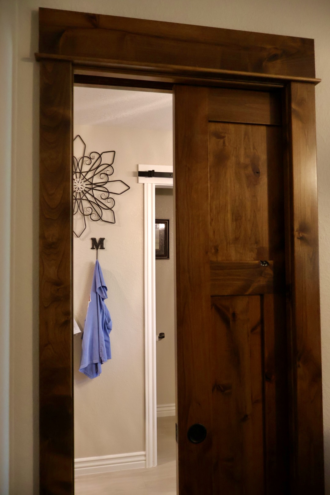 Partly open alder pocket door with matching wood casing